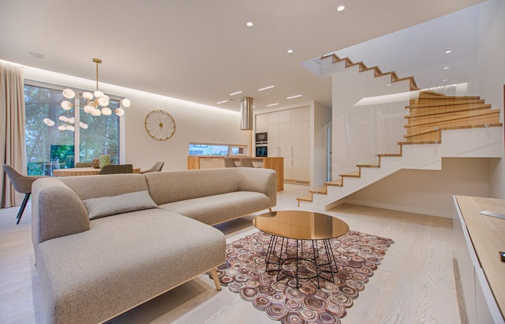 pexels-photo-1571460 Contemporary living room with neutral tones, a sleek sofa, and elegant wooden staircase.